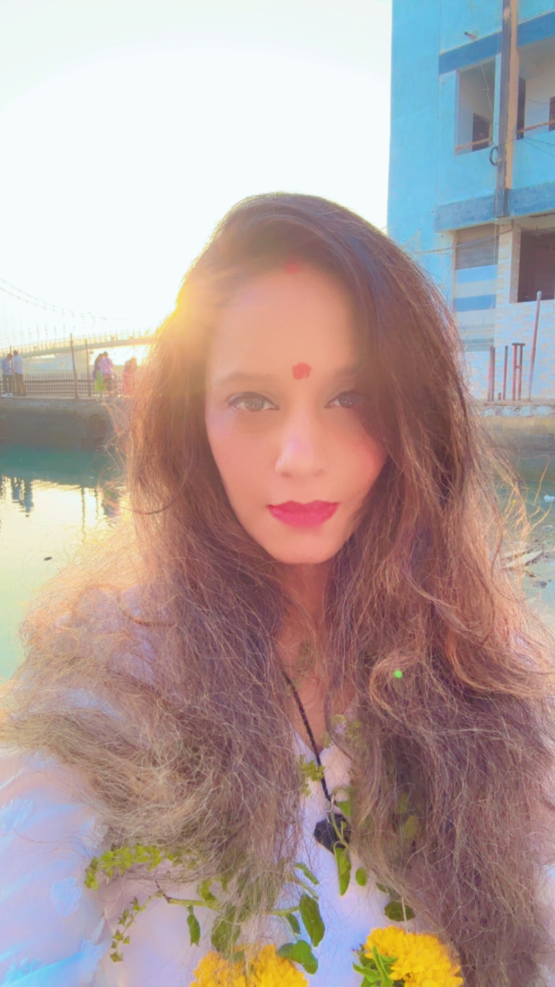 Suhaila in sunlight with marigold flowers